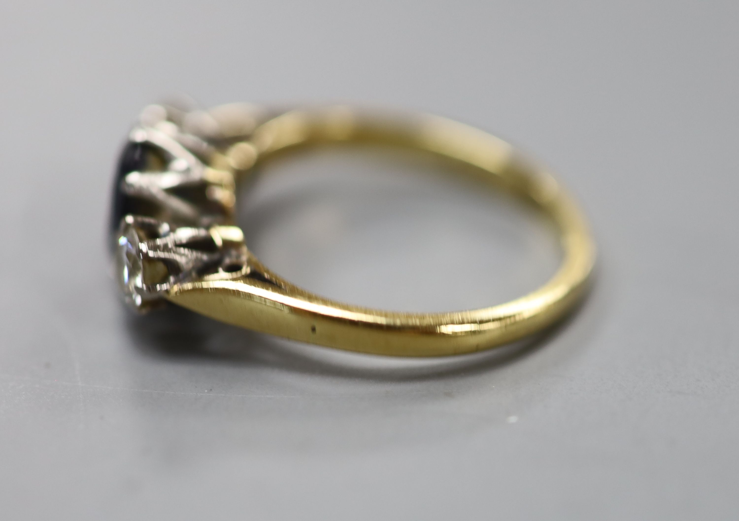 A sapphire and diamond three-stone ring, 18ct gold and platinum setting, size K, gross 3.3 grams.
